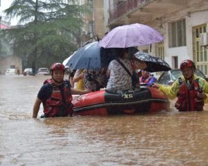 Rescuers evacuate trapped residents from a flood-affected in Loudi, in China's Hunan Province....