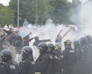 Police officers face protesters during an anti-immigration demonstration outside the Holiday Inn...