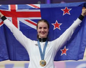 Ellesse Andrews holds the New Zealand flag aloft after being presented her gold medal for the...