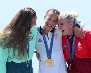 Dame Lisa Carrington (C) with Hungary's silver medallist Tamara Csipes (L) and Denmark's bronze...