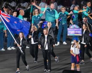 Anna Grimaldi and Cameron Leslie, flag bearers of Team New Zealand, hold their national flag as...