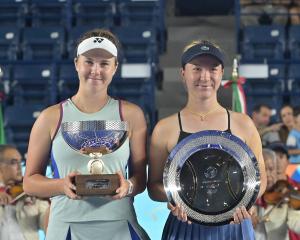 Linda Noskova (left) of Czech Republic and Lulu Sun of New Zealand hold their respective trophies...