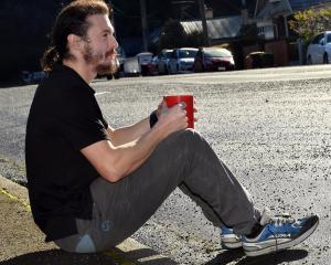 Dunedin resident Isaac Tripp sits on the side of the road where his car should be parked. PHOTO:...