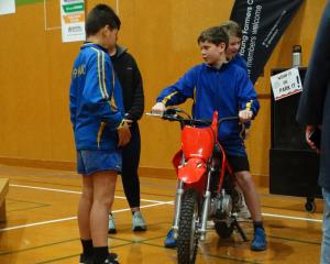 Papakaio School pupil Ari Wright, 10, gets to sit on a motorbike, while Seb McKenzie, 11, looks...