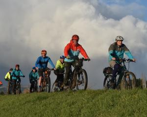 Colin Brown leads a group of cyclists along the Silver Stream floodbank near Mosgiel yesterday....