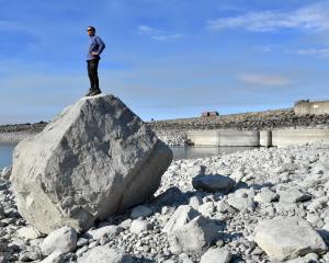 Grant Pearson studies Lake Pukaki from a rock near the outlet which is covered with water when...