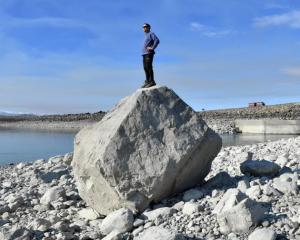 Grant Pearson studies Lake Pukaki from a rock near the outlet which is covered with water when...