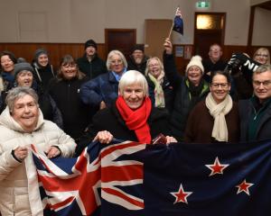 Val Butcher (centre) leads a group of Ophir residents cheering on her grandson Finn Butcher, who...
