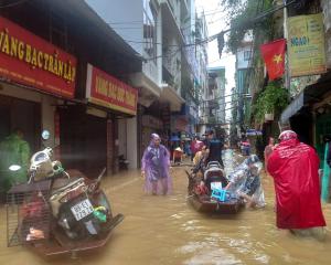 People wade through a flooded street in Hanoi following the impact of Typhoon Yagi. Photo: Reuters