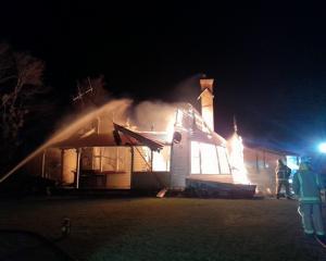 Firefighters douse the flames coming from the homestead at Hinds on Sunday. PHOTO: SUPPLIED