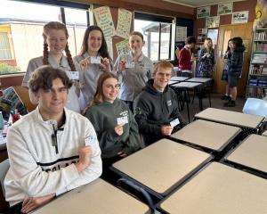 Holding their kindness initiative cards are Dunstan High School students (back, from left)...