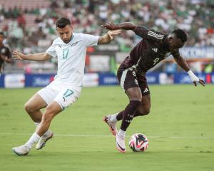 Kosta Barbarouses of New Zealand and Julian Quinones of Mexico vie for the ball in the first half...