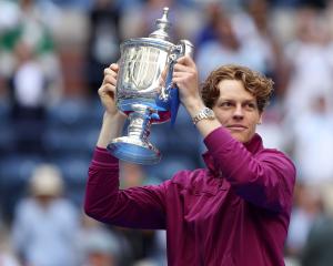 Jannik Sinner holds the US Open trophy aloft after beating American Taylor Fritz in straight sets...