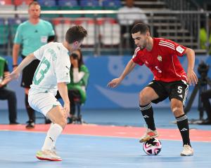 Futsal Whites player Oban Hawkins, of Dunedin, tries to shut down Libyan attacker Siliman...