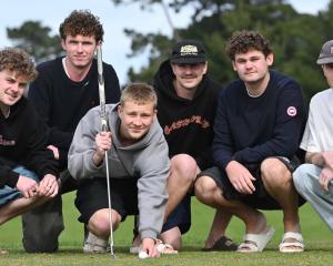 University of Otago commerce student Tommy Cummins, 19, lines up a shot under the eagle eye of...