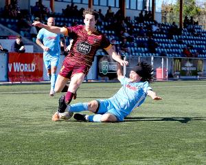 Coastal Spirit’s Sako Satsumi wins the ball off Universities’ Hunter Hine during his side’s 2-1...