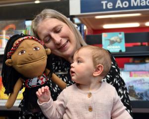 Mosgiel Library librarian assistant Kerri Hayes holds 9-month-old Lyra Parata-Mercer and a Māori...