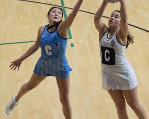 Milla Cashmore of Columba secures a pass despite the attention of Kyla Ashton  during the Otago...