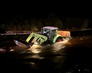 A tractor, with six occupants, was stuck in the middle of a surging river on the West Coast at...