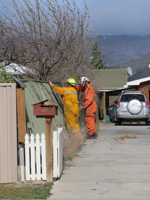 Two rural firefighters secure a wooden fence on Fache St. Photo: Yvonne O'Hara 