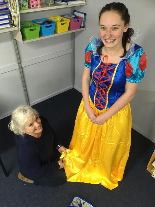 Backstage crew member Sue Scott (left) adjusts Lucy Neilson’s hem in preparation for her role....