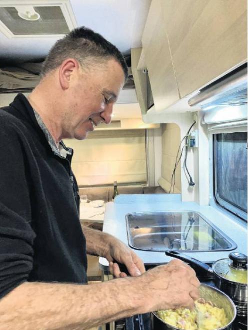 Chris cooks dinner in our warm and cosy Maui motorhome, a vast contrast to the conditions endured...