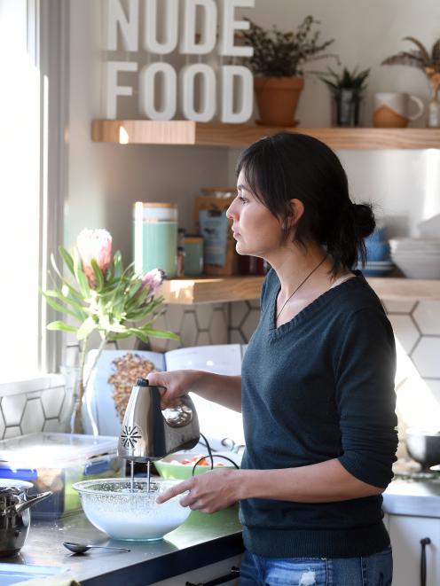 Nadia Lim watches her chickens while making chocolate mousse in her kitchen.