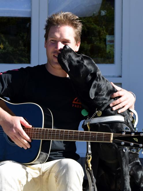 Bevan Gardiner  reacts after his guide dog Faith licks his face.