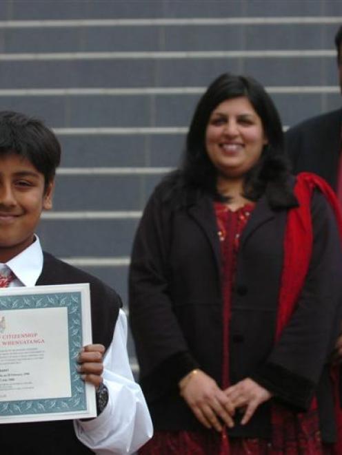 Avinash Shastri holds his citizenship certificate watched by his mother, Vidya Kulkarni, and...