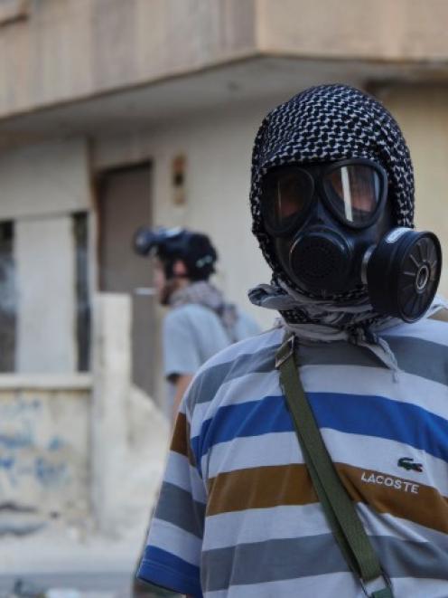 An activist wearing a gas mask is seen in the Zamalka area, where activists say chemical weapons...