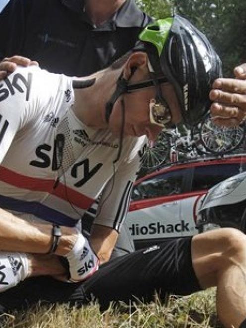Bradley Wiggins of Britain holds his left shoulder after crashing during the seventh stage of the...