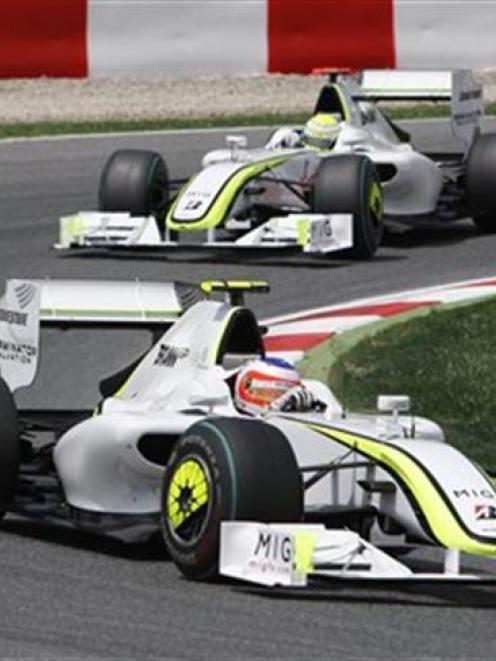 Brawn GP driver Rubens Barrichello of Brazil, bottom, drives his car ahead of Brawn GP Jenson...