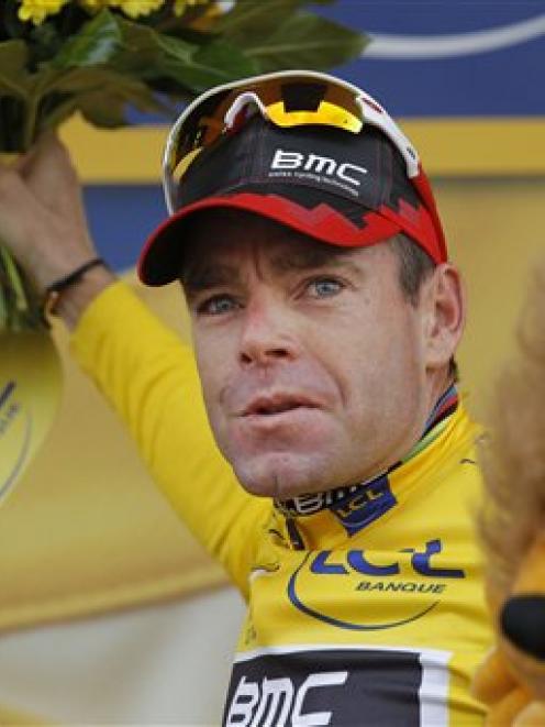 Cadel Evans of Australia throws flowers to cheering fans on the podium of the 20th stage of the...