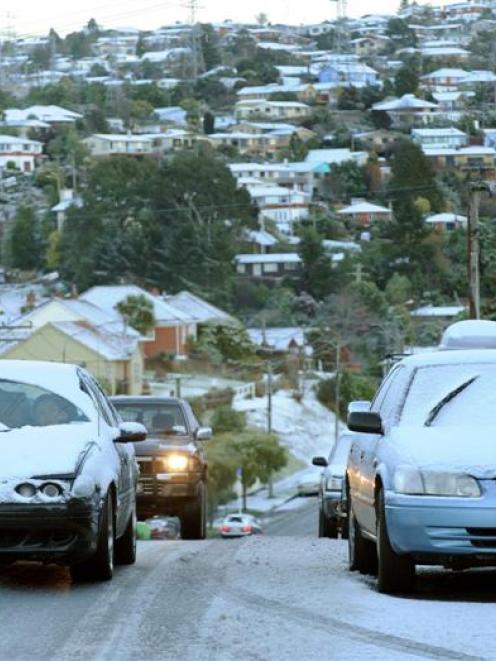 Cars negotiate a snowy Dalziel Road. Photo by Stephen Jaquiery