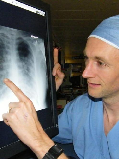 Dunedin Hospital ICU consultant Dr Matthew Bailey examines an X-ray of the air-starved lungs of a...