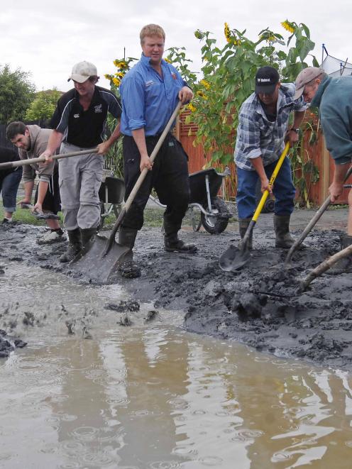 Farmers from Waiau in North Canterbury help clean up Birch St in Bexley, which was affected by...