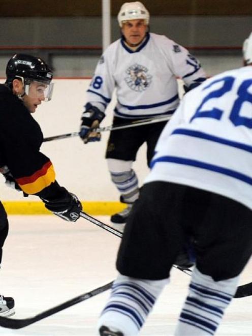 In action at the Dunedin Ice Stadium are (from left) Queenstown Jurassics player Chris Hansen and...