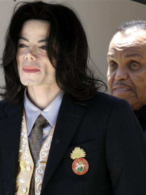 Michael Jackson walks with his father Joe, right, after a day of testimony in his child...