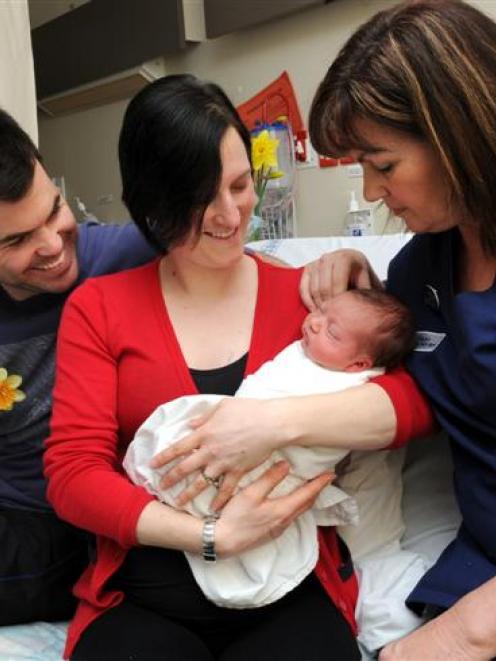 Newborn Jake is cradled by mother Angie Lucas, while father Tim Lucas, and midwife Anne Jenkins...