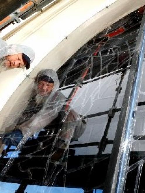 Otago stained glass artist Peter Mackenzie tightens the bolts on the polycarbonate shields which...