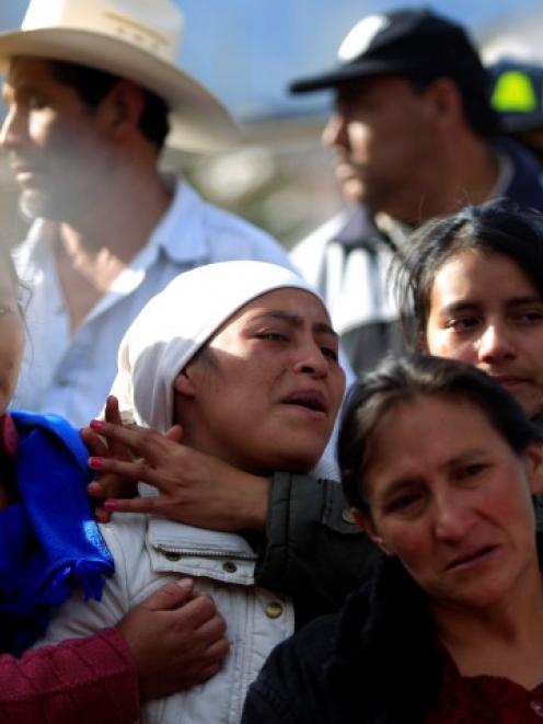 Relatives of a man react after his body was found in a landslide triggered by an earthquake, in...