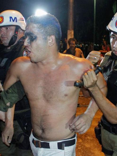 Riot police detain a demonstrator during a violent protest in Belem, at the mouth of the Amazon...