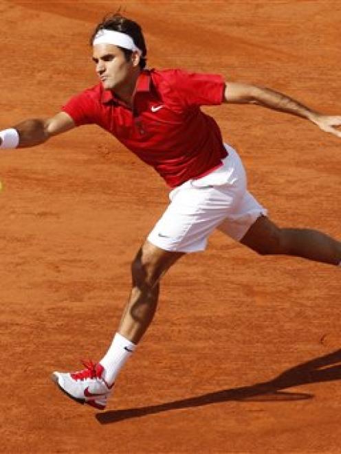 Roger Federer of Switzerland returns against Gael Monfils of France in their French Open...