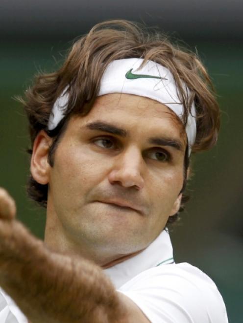 Roger Federer of Switzerland serves to Fabio Fognini of Italy during their men's singles match at...