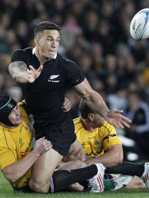 Sonny Bill Williams offloads in the tackle of Berrick Barnes and Quade Cooper.  REUTERS/Nigel Marple