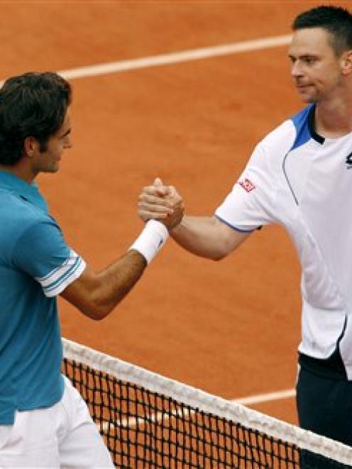 Switzerland's Roger Federer, left, shakes hands with Sweden's Robin Soderling after being...