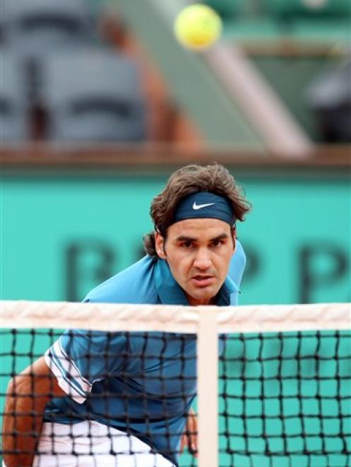 Switzerland's Roger Federer watches the ball go over the net as he returns to Colombia's...