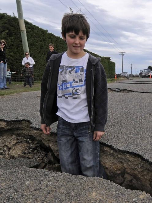Taylor Strowger (10) from Darfield explores earthquake damage to Highfield Road, 30km west of...