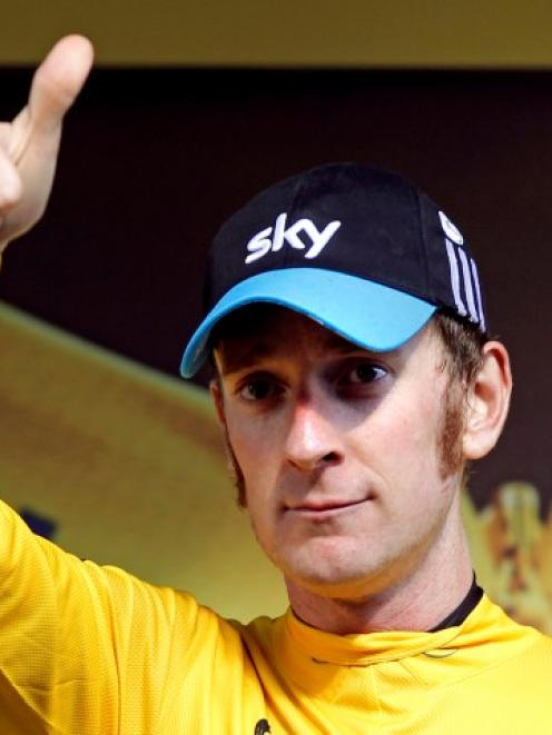 Team Sky rider Bradley Wiggins of Britain acknowledges supporters from the podium after winning...