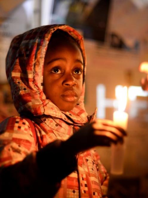 Wellwishers hold candles as they gather in support of ailing former South African President...